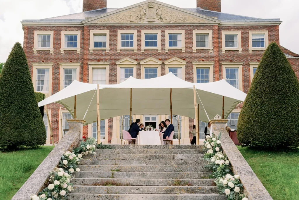 Intimate Wedding party dining under a stretch tent outside private stately home in Kent. Planned by luxury marquee wedding planner Natasha Spencer