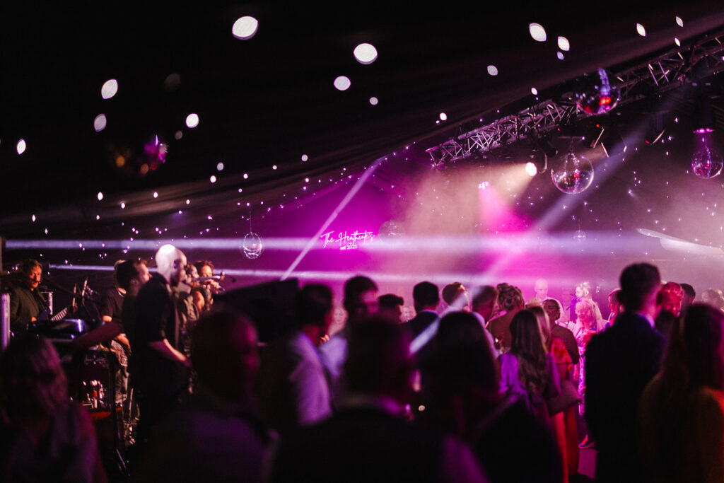 Wedding party in full swing with guests dancing and laser lights in a luxury marquee planned by luxury marquee wedding planner Natasha Spencer at a family farm near Ashford, Kent